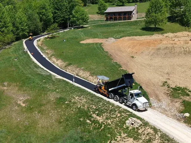 Paving a long drive through a field, seen from the air