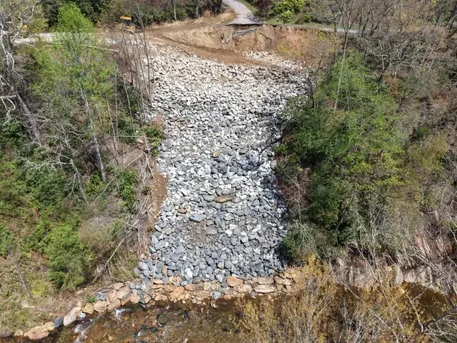 Rock fill in a steep draw below a road, seen from the air