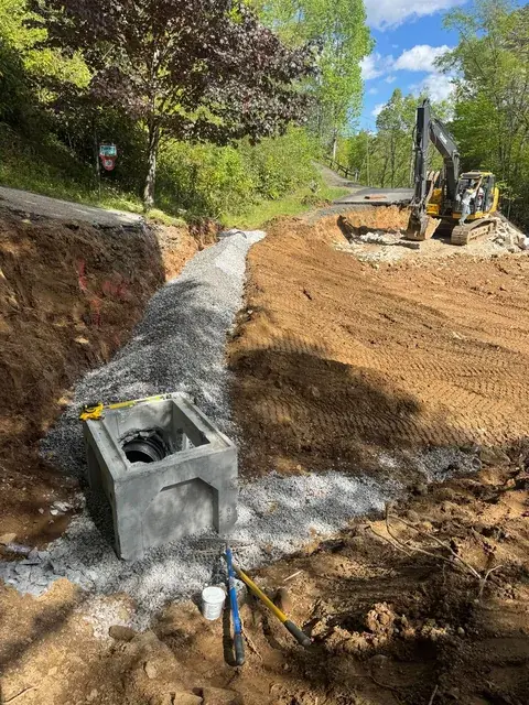 A catch basin set into a graded slope with stone