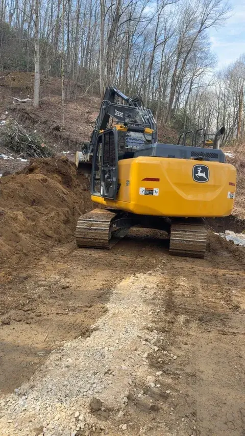 An excavator on a graded dirt site