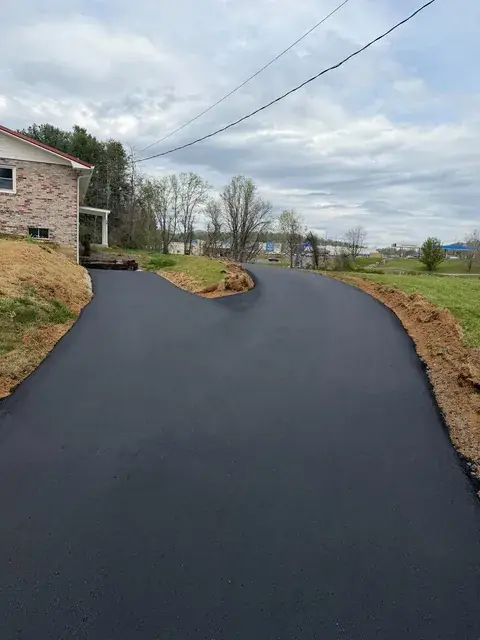 A new paved drive beside a brick house