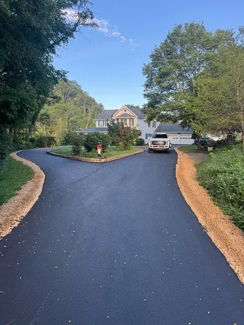 A freshly paved driveway leading up to a house