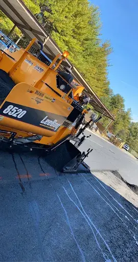 An asphalt paver at work, seen from the side