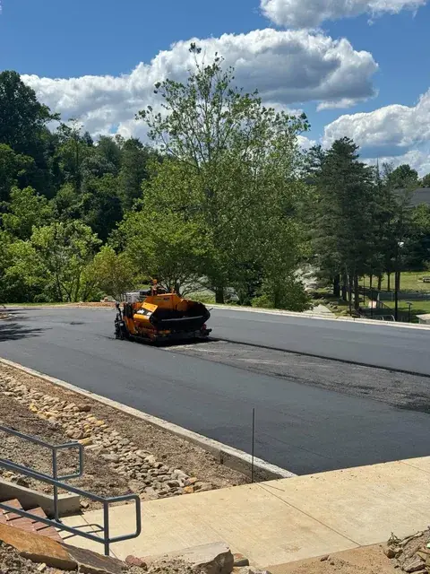 A paver on a new lot beside a concrete walk and railing