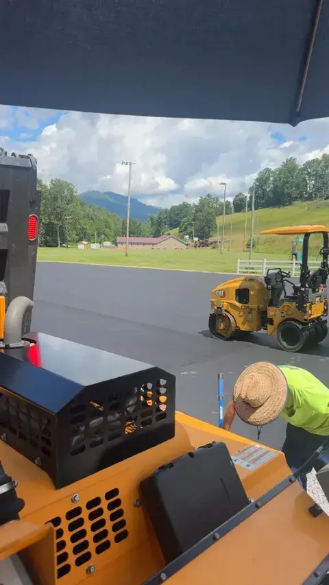 A roller on fresh asphalt, seen from the paver
