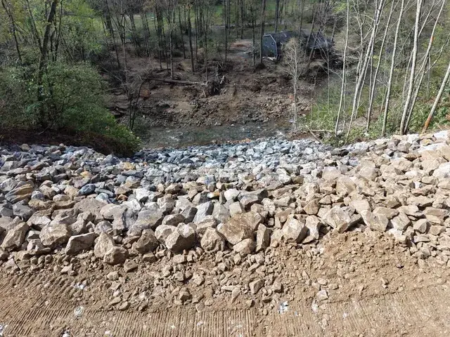 Large rock placed on a slope above a stream