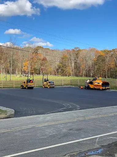 Rollers and a paver on a newly paved lot