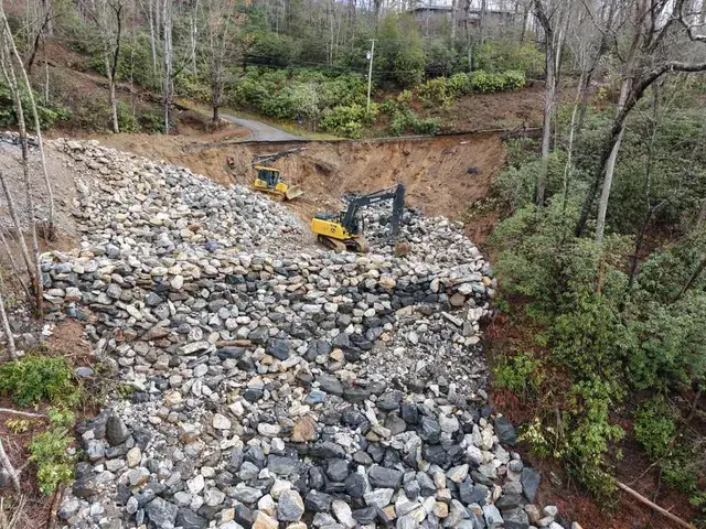 Excavators placing rock on a rebuilt slope