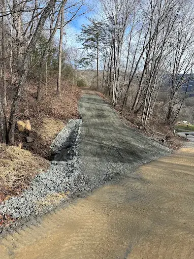 Stone and gravel along a graded slope beside a drive