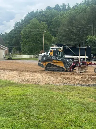 A track loader grading ground beside a field